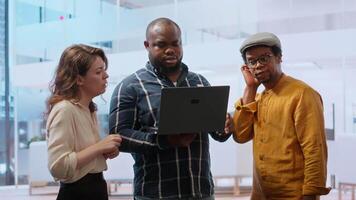 Real estate agent presenting a new office building to clients, discussing the detailed blueprints using a tablet during the property tour. Potential leasing investment opportunity. Camera B. video
