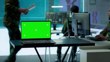 Military IT specialist in command center working on collecting field data, process real time surveillance footage and imagery for successful defense operation. Isolated mockup display on pc. Camera A. video