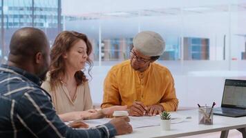 Real estate agent presenting the property investment opportunity available from leasing the new high class office space. Realtor evaluating blueprints and building layouts at desk. Camera B. video