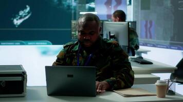 Army intelligence expert utilizes modern computer systems and satellite radar imagery to enhance national security, strategic initiatives and ensure defense in mission control center. Camera A. video