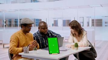 Businessman discussing with the real estate agents next to chroma key on tablet, meeting to negotiate leasing contract terms before looking at blueprints for an office relocation. Camera A. video
