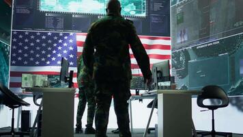 US soldiers in a high tech command center protecting classified information, ensuring cybersecurity and defending against cyber attacks. Army base of operations with trained officers. Camera B. video
