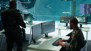 Soldier working with AI intelligence on pc in control room, processing live data on cctv systems. Surveillance efforts to support field missions and defense operations, national security. Camera B. video