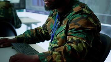Army professionals in command post overseeing satellite data and real time surveillance, mission intelligence. Support strategic military operations, studying world map and big screen. Camera A. video