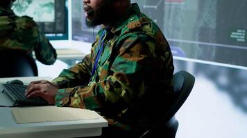 Military control room features army personnel monitoring surveillance systems, soldiers integrating data and coordinating strategic missions. Support decision making and efficiency. Camera A. video