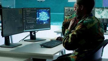 Programming engineer soldier handles AI brain and deep learning data on computer in command post, coordinates national defense operations. Neural network artificial intelligence science. Camera A. video
