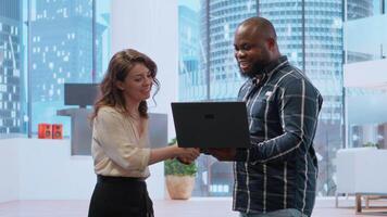 Realtor broker showing architectural blueprints on laptop to business team potential clients, presenting high class building space during tour. Offering insurance and legal assistance. Camera B. video