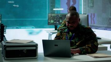 Military intelligence specialist uses high tech satellite systems and cctv radar to ensure national protocols, strategic missions for defense operation in command post control tower. Camera A. video