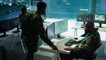 Army intelligence specialists using advanced computer systems and satellite data to enhance national security, critical information. Soldiers planning for mission in high tech control room. Camera B. video