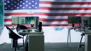 Empty military control center with a big screen shows the American flag, secret service agency protecting the country from threats. Army command room with high tech equipment. Camera A. video