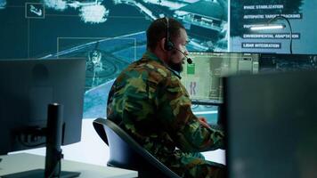 Soldiers in a modern command center analyze live data from cctv radar sources, satellite feeds and surveillance systems. Intelligence to support strategic planning and military operations. Camera A. video