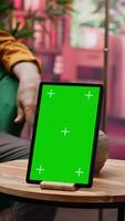 Vertical Two senior people having fun and chatting next to isolated chroma key screen on laptop, enjoying retirement time and relaxing together. Elderly couple with free time, leisure activity. Camera A. video