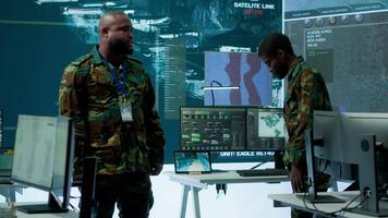 Military personnel operate advanced systems in a command center, focusing on surveillance and data analysis to protect national security. Soldiers trained to manage information warfare. Camera A. video