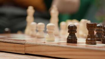 Happy senior people playing chess in a cozy home setting, thinking about strategy moves during board game leisure activity. Enjoyment of strategic intellectual hobby, mastermind pastime. Camera A. video