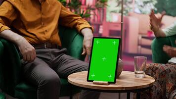 Two senior people having fun and chatting next to isolated chroma key screen on laptop, enjoying retirement time and relaxing together. Elderly couple with free time, leisure activity. Camera A. video