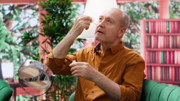 Elderly man applying rejuvenating serum and UV protection as a daily routine for skincare and anti aging, cosmetology. Senior person using cream moisturizer on his aging face, grooming. Camera A. video