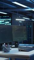 Vertical Data center business with networking systems installed used for managing mainframes. Code running on computers in futuristic server room used for overseeing equipment, dolly in shot video