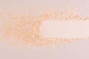 A sample, a stripe, an imprint of loose powder of a natural tone on a beige background. Delicate texture. Breathable powder without weighing it down photo