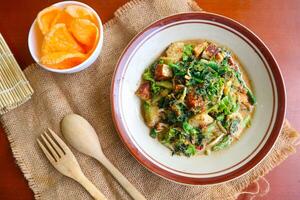 lotek is a traditional salad from Indonesia made from vegetable, chayote, kale, young jackfruit, tempeh, tofu, long beans, and bean sprouts with peanut sauce and cracker photo