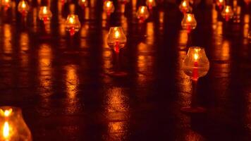 A large number of candles are lit at borobudur temple. The candles are arranged in a pattern, with some candles grouped together and others spaced apart. Scene is one of warmth and coziness photo