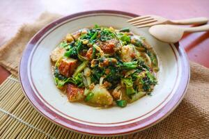 lotek is a traditional salad from Indonesia made from vegetable, chayote, kale, young jackfruit, tempeh, tofu, long beans, and bean sprouts with peanut sauce and cracker photo