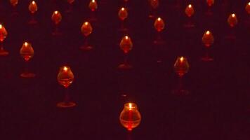 A large number of candles are lit at borobudur temple. The candles are arranged in a pattern, with some candles grouped together and others spaced apart. Scene is one of warmth and coziness photo