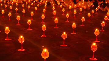 A large number of candles are lit at borobudur temple. The candles are arranged in a pattern, with some candles grouped together and others spaced apart. Scene is one of warmth and coziness photo
