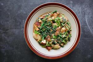 lotek is a traditional salad from Indonesia made from vegetable, chayote, kale, young jackfruit, tempeh, tofu, long beans, and bean sprouts with peanut sauce and cracker photo