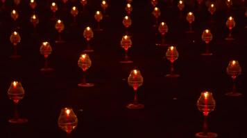 A large number of candles are lit at borobudur temple. The candles are arranged in a pattern, with some candles grouped together and others spaced apart. Scene is one of warmth and coziness photo
