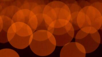bokeh blurry, orange and black photo of a bunch of small circles. The circles are all different sizes and are scattered throughout the photo. Scene is somewhat chaotic and disorganized