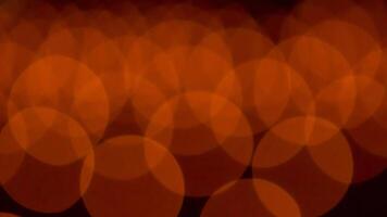 bokeh blurry, orange and black photo of a bunch of small circles. The circles are all different sizes and are scattered throughout the photo. Scene is somewhat chaotic and disorganized