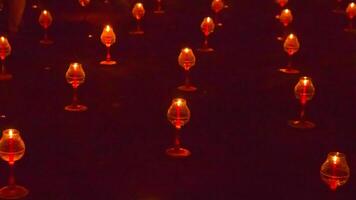 A large number of candles are lit at borobudur temple. The candles are arranged in a pattern, with some candles grouped together and others spaced apart. Scene is one of warmth and coziness photo