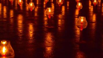A large number of candles are lit at borobudur temple. The candles are arranged in a pattern, with some candles grouped together and others spaced apart. Scene is one of warmth and coziness photo