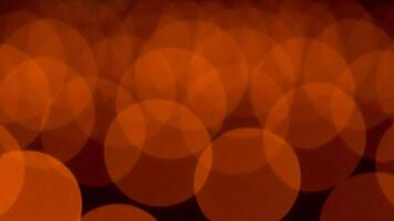 bokeh blurry, orange and black photo of a bunch of small circles. The circles are all different sizes and are scattered throughout the photo. Scene is somewhat chaotic and disorganized