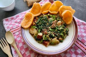 lotek is a traditional salad from Indonesia made from vegetable, chayote, kale, young jackfruit, tempeh, tofu, long beans, and bean sprouts with peanut sauce and cracker photo