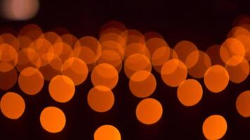 bokeh blurry, orange and black photo of a bunch of small circles. The circles are all different sizes and are scattered throughout the photo. Scene is somewhat chaotic and disorganized