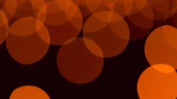 bokeh blurry, orange and black photo of a bunch of small circles. The circles are all different sizes and are scattered throughout the photo. Scene is somewhat chaotic and disorganized