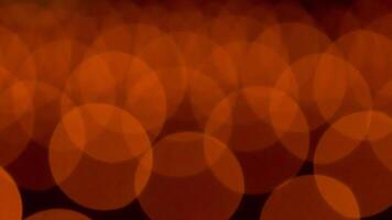 bokeh blurry, orange and black photo of a bunch of small circles. The circles are all different sizes and are scattered throughout the photo. Scene is somewhat chaotic and disorganized