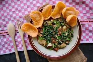 lotek is a traditional salad from Indonesia made from vegetable, chayote, kale, young jackfruit, tempeh, tofu, long beans, and bean sprouts with peanut sauce and cracker photo