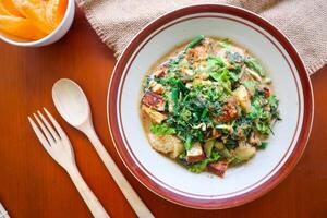 lotek is a traditional salad from Indonesia made from vegetable, chayote, kale, young jackfruit, tempeh, tofu, long beans, and bean sprouts with peanut sauce and cracker photo