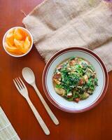 lotek is a traditional salad from Indonesia made from vegetable, chayote, kale, young jackfruit, tempeh, tofu, long beans, and bean sprouts with peanut sauce and cracker photo