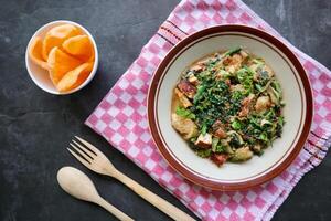 lotek is a traditional salad from Indonesia made from vegetable, chayote, kale, young jackfruit, tempeh, tofu, long beans, and bean sprouts with peanut sauce and cracker photo