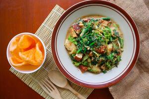 lotek is a traditional salad from Indonesia made from vegetable, chayote, kale, young jackfruit, tempeh, tofu, long beans, and bean sprouts with peanut sauce and cracker photo