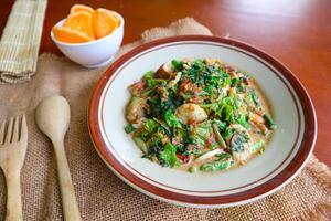 lotek is a traditional salad from Indonesia made from vegetable, chayote, kale, young jackfruit, tempeh, tofu, long beans, and bean sprouts with peanut sauce and cracker photo