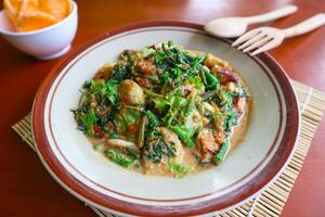 lotek is a traditional salad from Indonesia made from vegetable, chayote, kale, young jackfruit, tempeh, tofu, long beans, and bean sprouts with peanut sauce and cracker photo