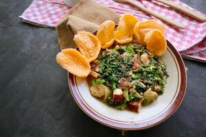 lotek is a traditional salad from Indonesia made from vegetable, chayote, kale, young jackfruit, tempeh, tofu, long beans, and bean sprouts with peanut sauce and cracker photo