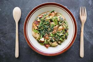 lotek is a traditional salad from Indonesia made from vegetable, chayote, kale, young jackfruit, tempeh, tofu, long beans, and bean sprouts with peanut sauce and cracker photo