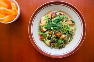 lotek is a traditional salad from Indonesia made from vegetable, chayote, kale, young jackfruit, tempeh, tofu, long beans, and bean sprouts with peanut sauce and cracker photo