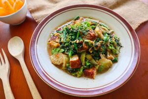 lotek is a traditional salad from Indonesia made from vegetable, chayote, kale, young jackfruit, tempeh, tofu, long beans, and bean sprouts with peanut sauce and cracker photo