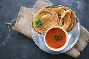 Roti Canai or Paratha Bread with Curry Sauce, Chilli Flakes and Yogurt, Top View photo